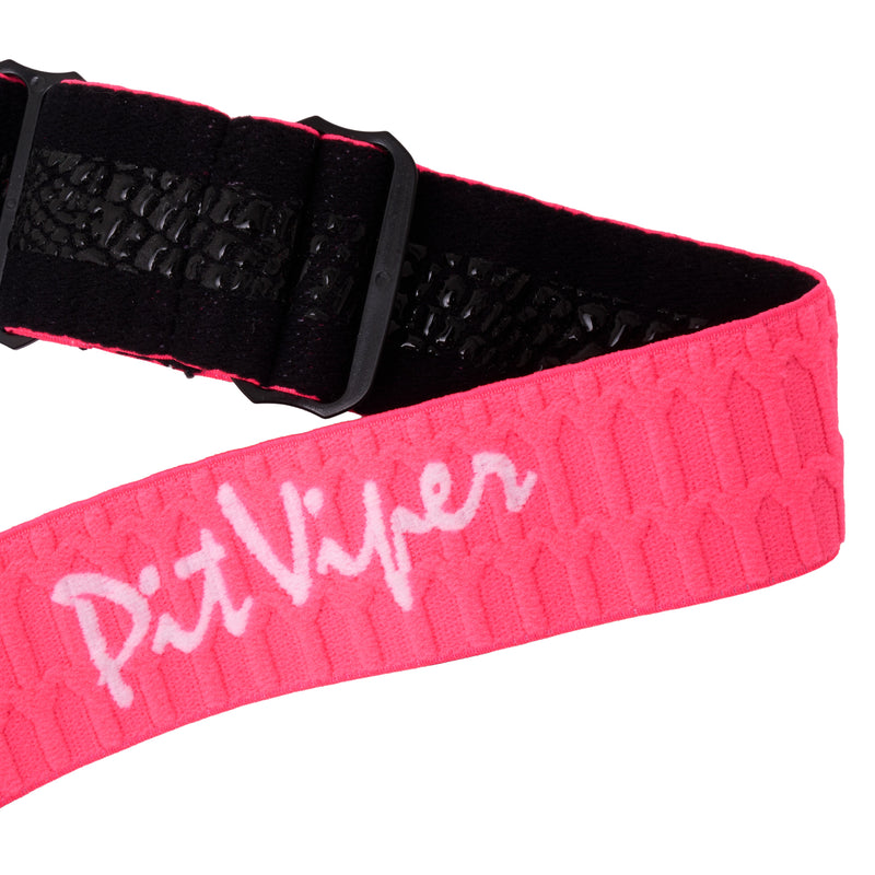 | it_a_strap.JPG | A close-up of a bright pink textured belt with a black buckle and black interior lining, featuring the white script logo 'Pit Viper' across the front.