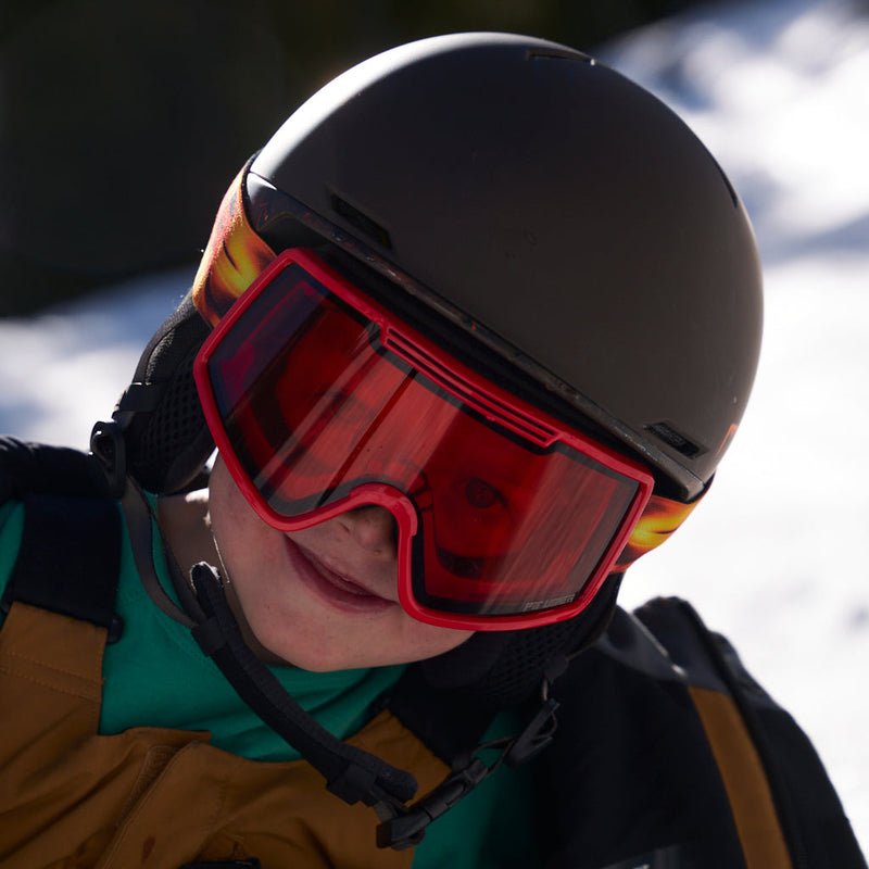 | photo_of_kid.JPG | Close-up of a person wearing a matte black ski helmet and red ski goggles, with a snowy outdoor background.