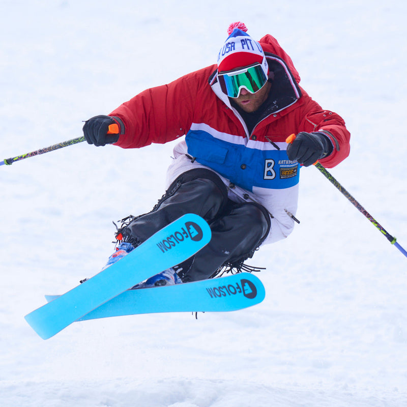 | action_chuck.JPG | Photo of skier catching air on skis wearing the USA Pom Pom Beanie