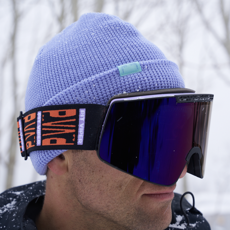 | photo_of_person.JPG | Photo of a person wearing a purple knit beanie with black and purple goggles in a snowy forest.