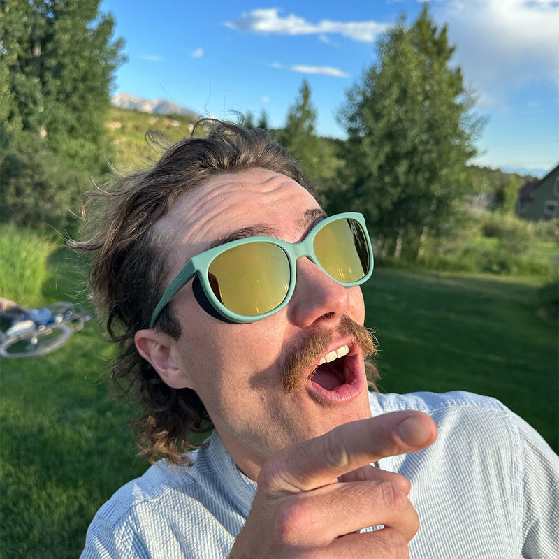/ Gold | photo_of_person_2.JPG | Man pointing at the sky wearing Pit Viper Sunglasses