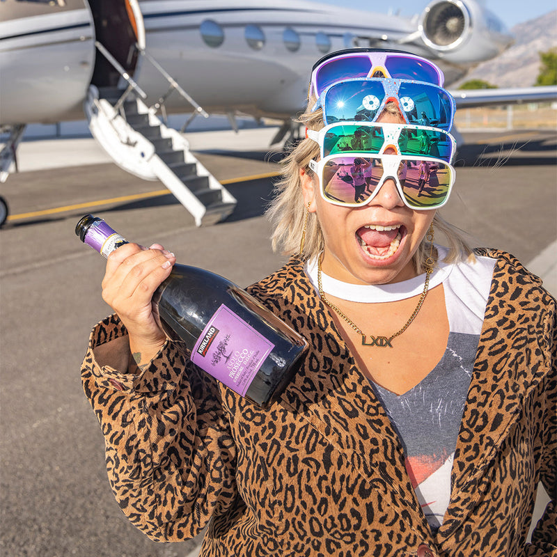 / Pink | photo_of_person.JPG | Woman posing with champagne wearing multiple pears of Pit Viper Sunglasses