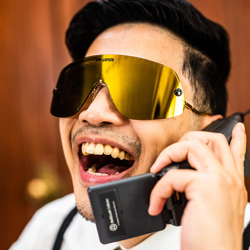 / Polarized Gold | photo_of_person_2.JPG | Man on the phone wearing The Money Counter Limousine from Pit Viper Sunglasses