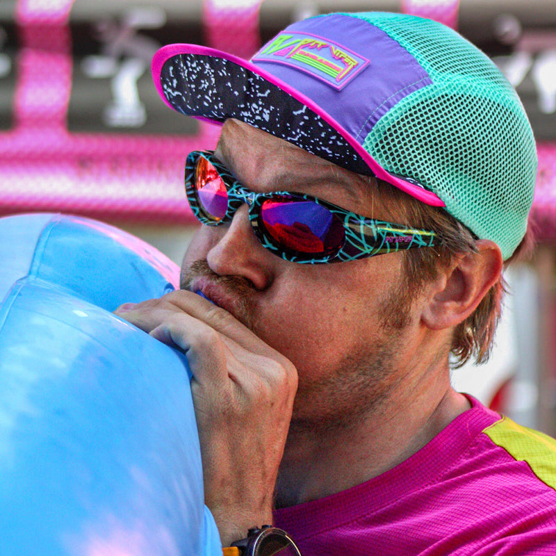  | photo_of_person.JPG | Man blowing up a pool toy wearing The Voltage Slammer from Pit Viper Sunglasses